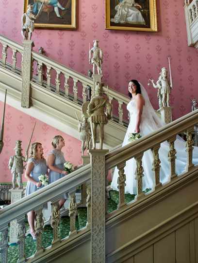 Bride meeting bridesmaids on staircase at Hartwell House