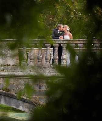 Bridal couple on bridge over lake at Hartwell House 