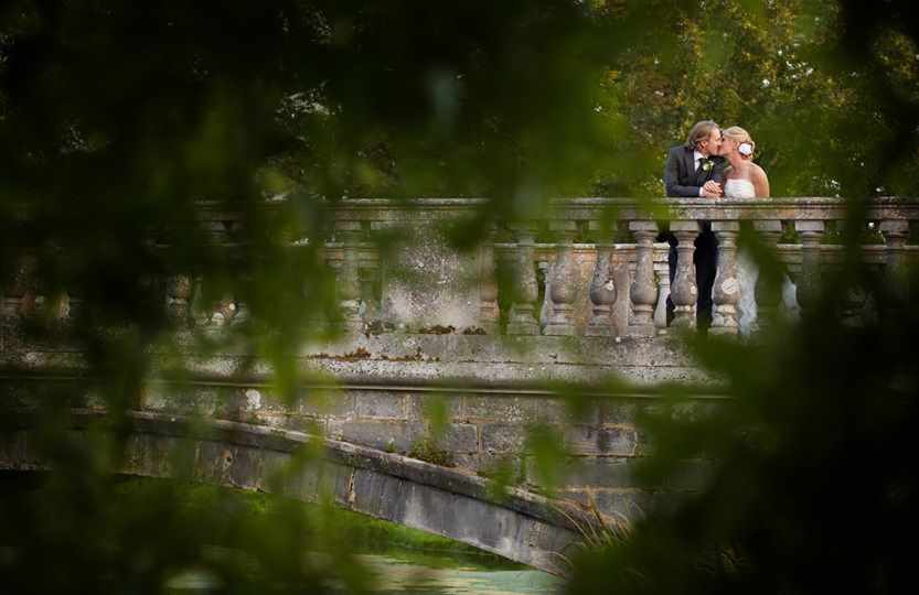 Bridal couple on bridge over lake at Hartwell House 